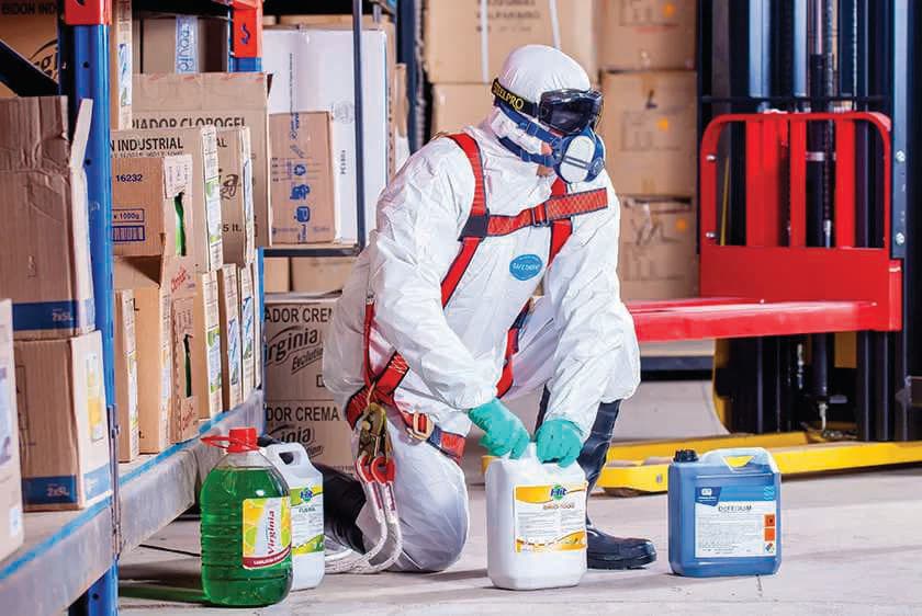 Technician in protective gear preparing disinfectants